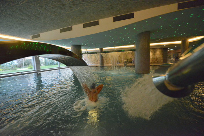 Mujer disfrutando de los chorros de espalda de la piscina dinámica del spa de la Residencia Spa de Felechosa